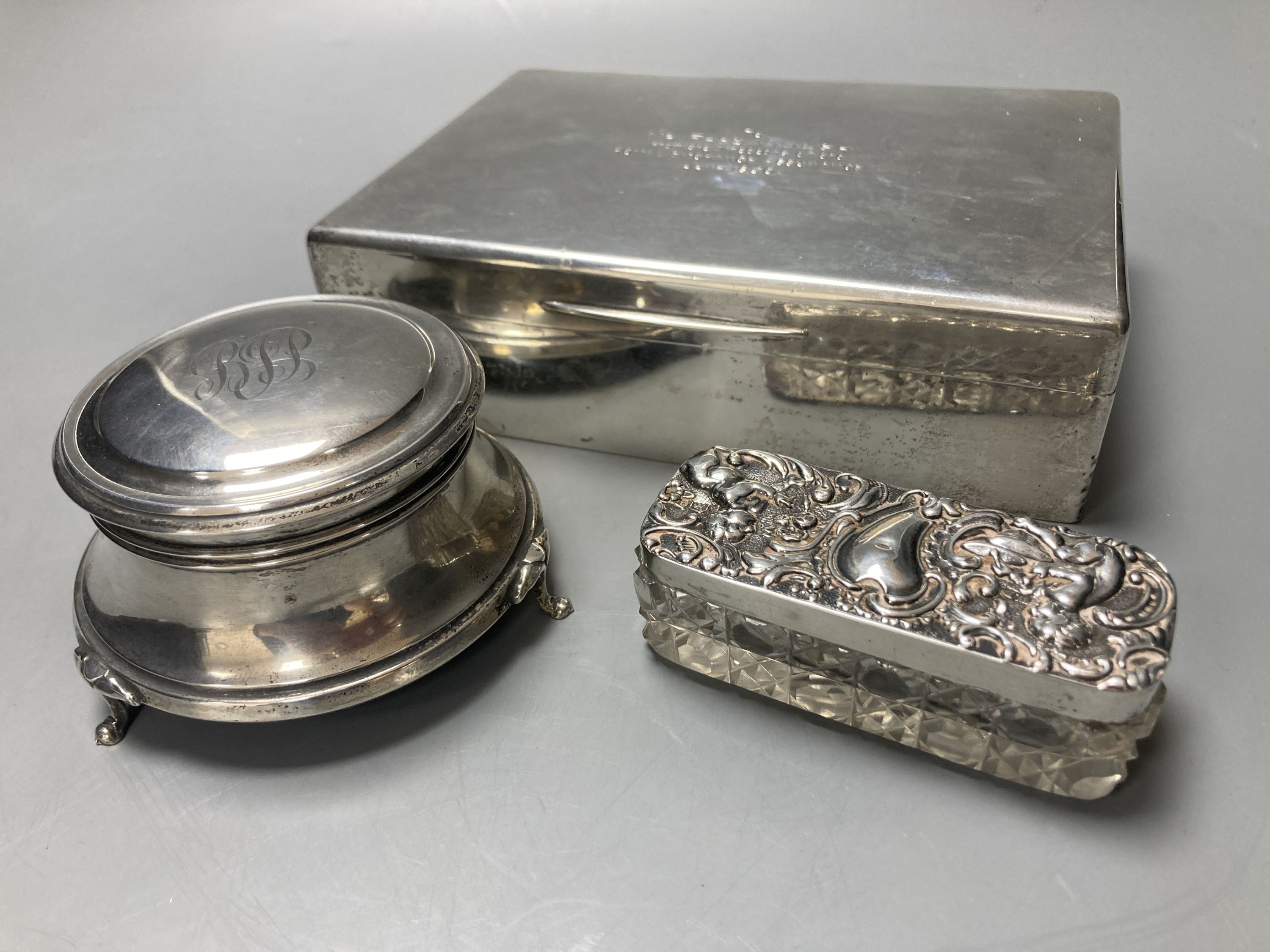 A silver cigar box, London 1928, 18cm, a silver ring box, Birmingham 1925, 9 cm diameter, and a silver topped pin box, 8.5 cm wide